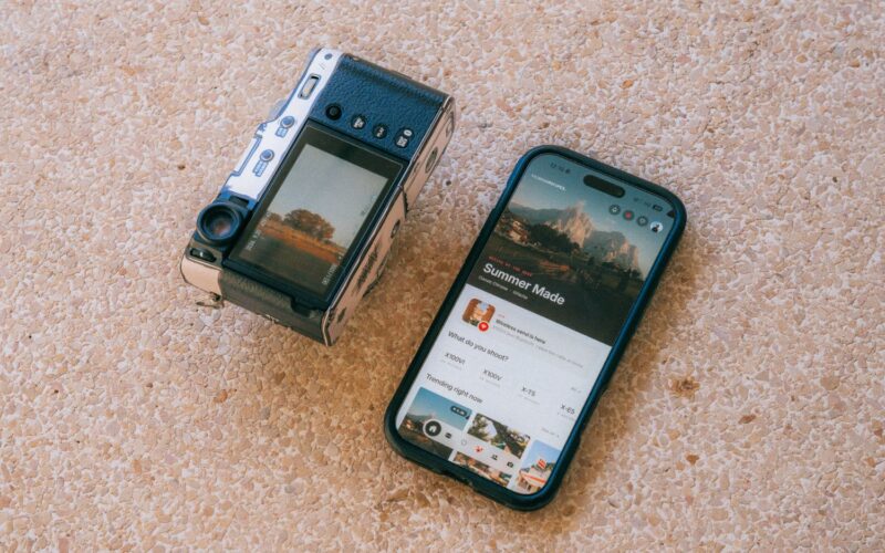 Fujifilm X100VI next to a phone with the Filmsim Recipes app